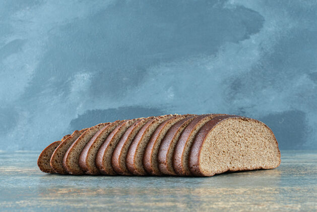 营养大理石背景上的棕色面包片切割面包棕色