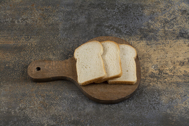 美味在木头砧板上放几片白吐司面包农业新鲜面包