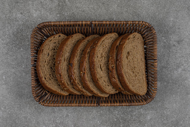 谷物木篮里的黑面包片有机深色新鲜