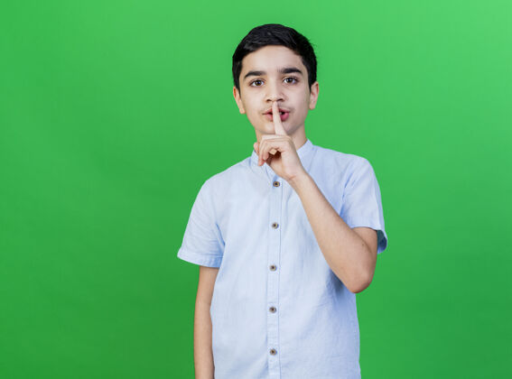 表达年轻的白人男孩做沉默的手势隔离在绿色的墙壁与复制空间沉默年轻人手势