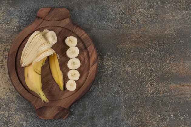 有机把香蕉削皮切片放在木板上零食热带农业