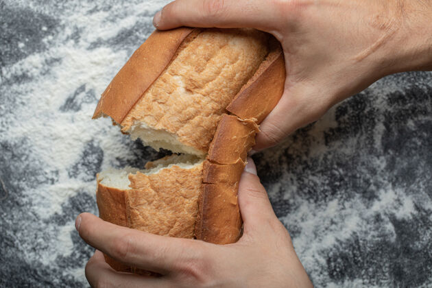 成人女性手掰新鲜出炉的面包 特写顶视图面包有机厨房