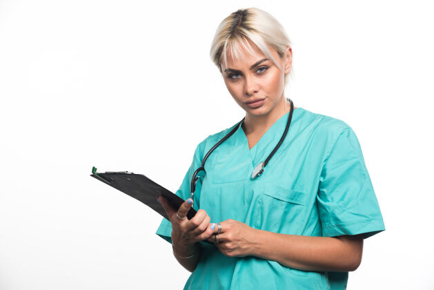 女士女医生用听诊器把剪贴板放在白色的表面上医生女性拿着