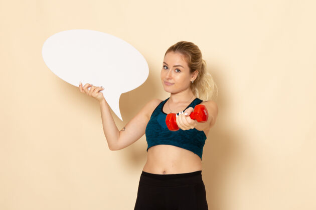 锻炼正面图身穿运动装的年轻女性手持哑铃和白色的演讲泡泡哑铃年轻女性锻炼