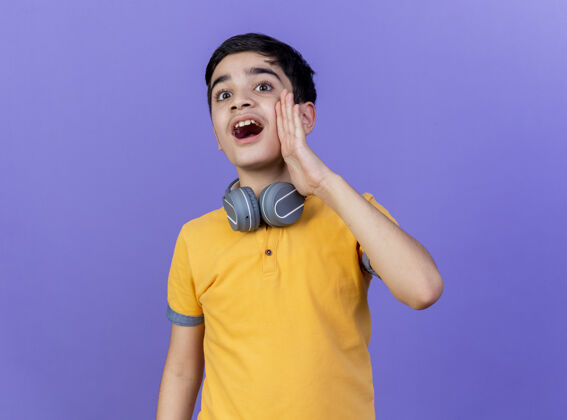 脖子年轻的白人男孩戴着耳机在脖子上孤立的紫色背景孩子耳机年轻