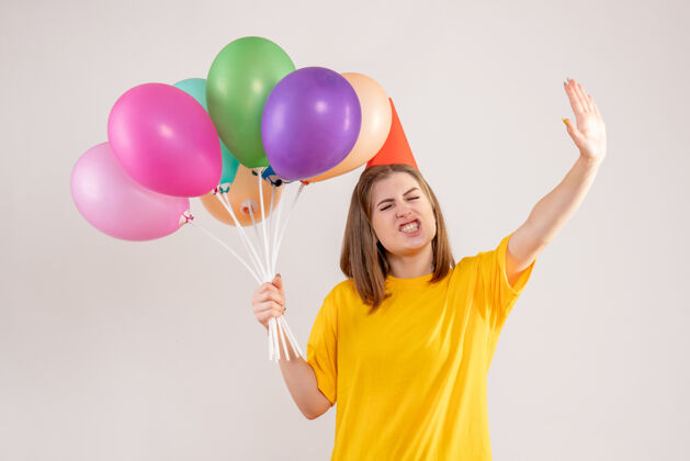 举行手持白色气球的年轻女子年轻女性乐趣气球