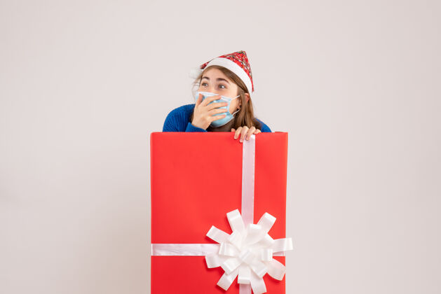 礼物年轻女子躲在礼物盒里 戴着白色面具圣诞节流行惊喜