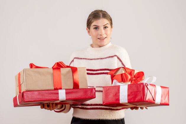 圣诞节年轻的女性手持圣诞礼物在白色情感人们年轻女性