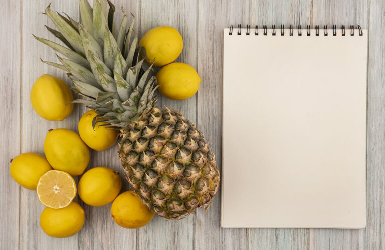 人顶视图的健康水果 如菠萝和柠檬隔离在一个灰色的木制墙壁与复制空间膳食木材水果