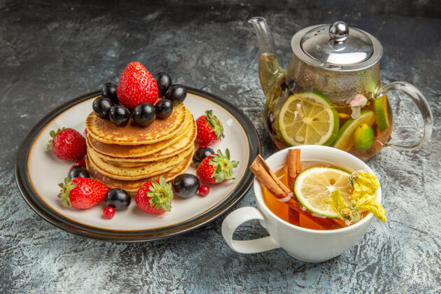 早餐正面是美味的薄煎饼 水果和茶放在薄薄的表面上 水果甜甜的早餐水果新鲜浆果