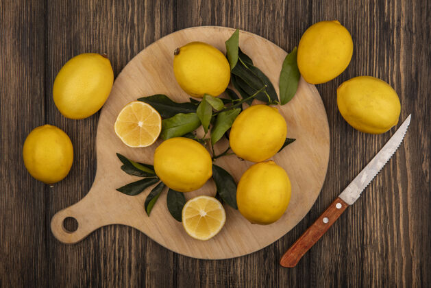 新鲜新鲜柠檬的顶视图被隔离在木制的厨房板上 刀子放在木制的墙上视图切片水果