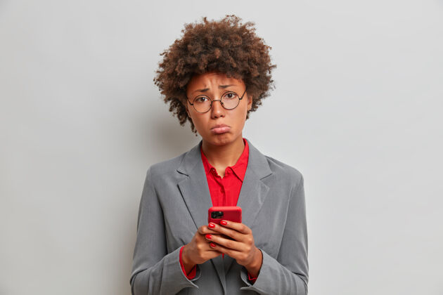 发短信伤心失望的女经理或行政助理在工作中有问题 使用手机 等待重要电话 无法解决困难的情况 站在室内技术女人女商人工作