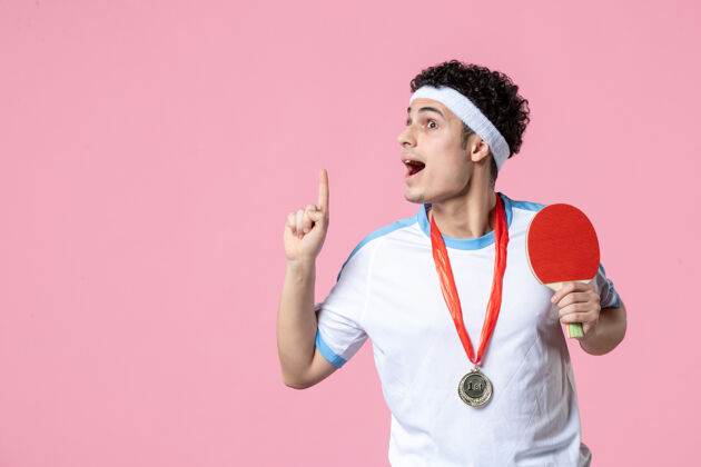 球员正面图身穿运动服的年轻男性 粉色墙上有奖牌乒乓球体育赢家
