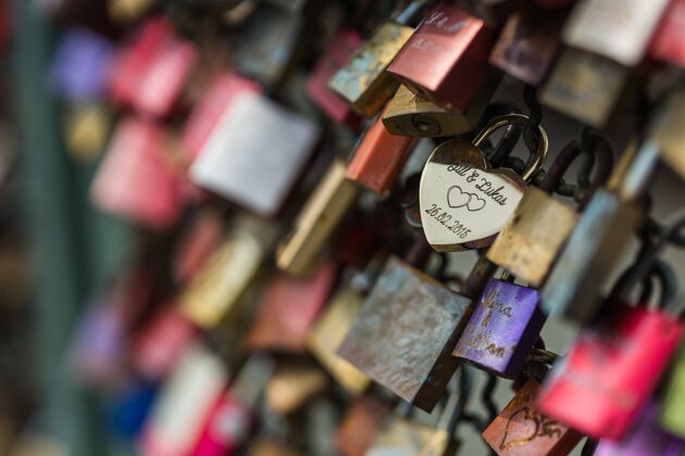 金属选择性聚焦拍摄的爱情挂锁在一个篱笆上关闭钥匙心