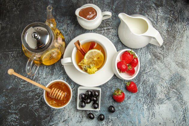 水果俯瞰一杯茶 在黑暗的表面上放上蜂蜜橄榄和水果早餐食物早餐早上橄榄