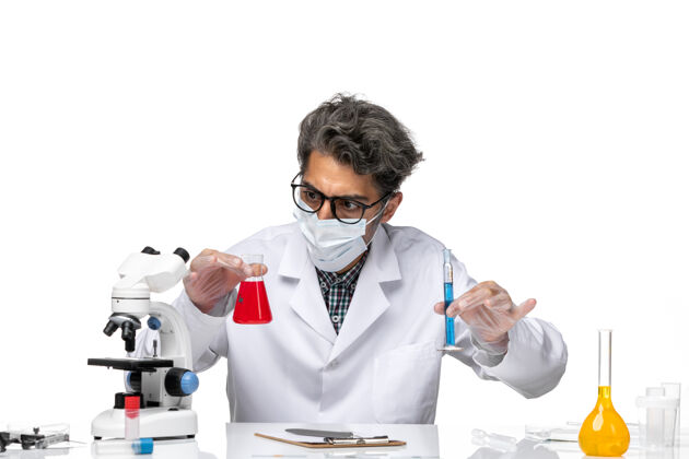 科学正面图穿着特殊套装的中年科学家拿着装有解决方案的烧瓶科学观点外套