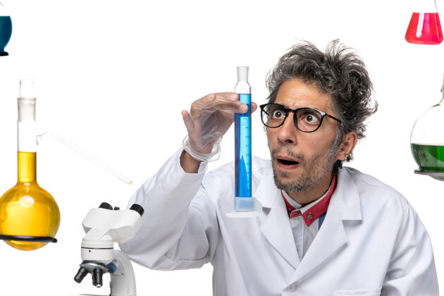 病毒前视图穿着医疗服的中年科学家正在用蓝色溶液工作工作医学人