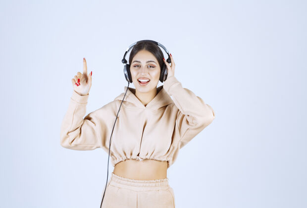 人类戴着耳机听音乐跳舞的年轻女子活跃女人音乐
