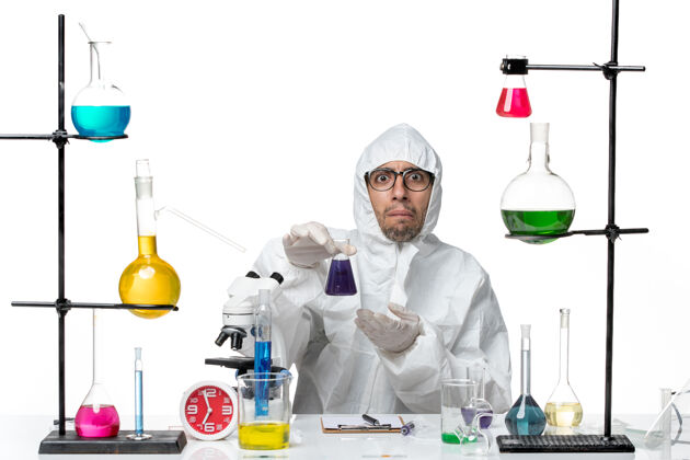 实验室正面图穿着特殊防护服的男科学家拿着装有溶液的烧瓶医学实验保护