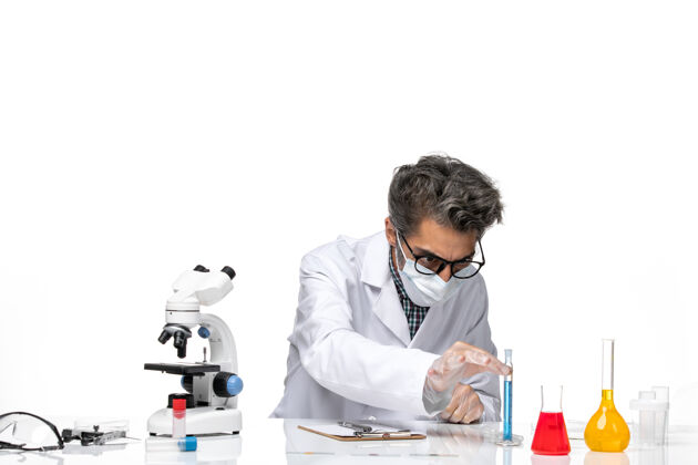 人正面图身着特殊套装的中年科学家围坐在桌子旁 拿着解决方案化学周围人