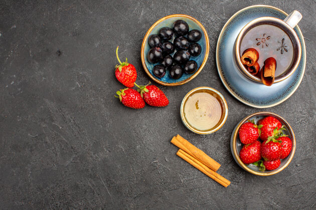 食品顶视图新鲜的红色草莓与茶和橄榄在黑暗的表面浆果新鲜水果橄榄新鲜可食用水果
