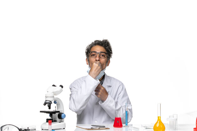 科学正面图身着特殊套装的中年科学家围坐在桌子旁 拿着解决方案周围前面人