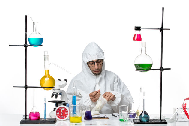 病毒正面图穿着特殊防护服的男科学家围坐在桌子旁 拿着解决方案实验室外套实验室科学