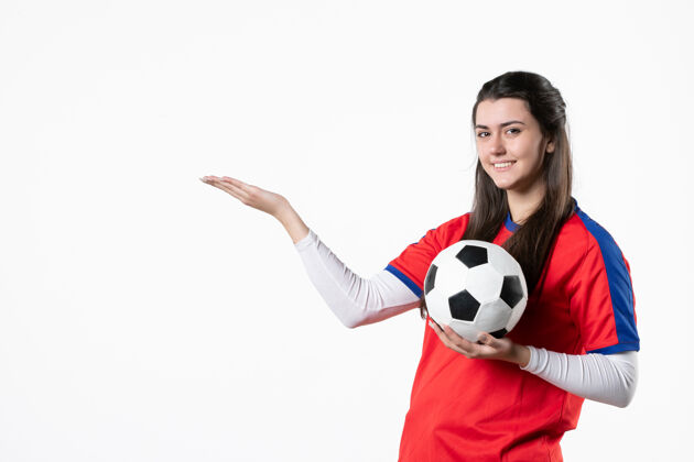 足球前视图穿着运动服的年轻女性 白色墙壁上有足球运动正面比赛
