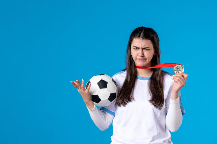 年轻女性正面图年轻女子拿着足球持球体育球