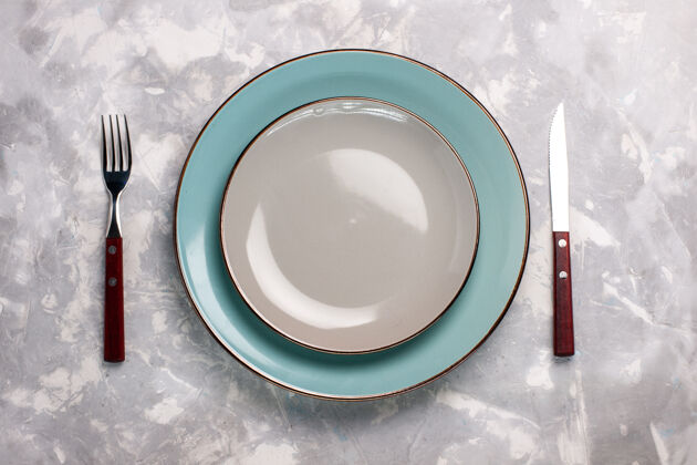 餐具白色表面上有刀叉的玻璃空盘子俯视图刀盘子杯子