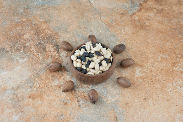 食物在大理石背景上放满葡萄干和坚果的小木碗大理石小葡萄干美味