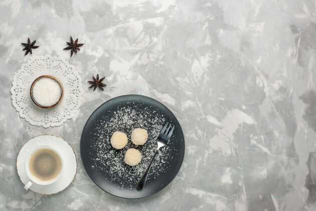 顶视图白色桌子上美味的椰子糖和咖啡的俯视图冷冬天雪
