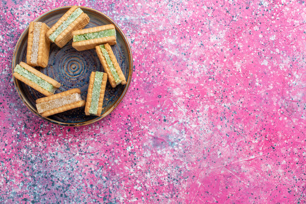 美味美味的华夫饼干在粉红色表面盘子里的顶视图金属盘子食物