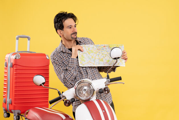 摩托车前视图年轻男子骑着自行车 拿着黄色的地图年轻男性乘坐设备
