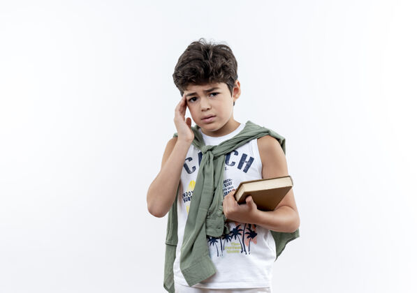 小悲伤的小男生拿着书 把手放在白色的额头上小学生额头手