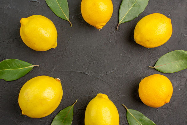 食物顶视图新鲜的酸柠檬衬在深色的餐桌上水果柑橘黄色的酸橙顶视图平铺多汁