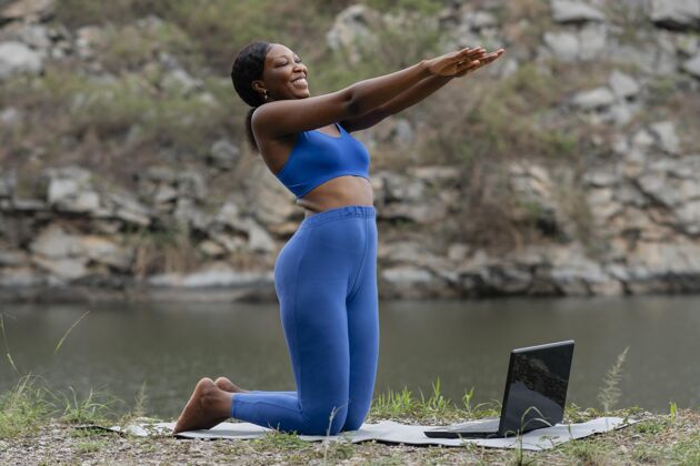 平静在网上教瑜伽的女人瑜伽老师姿势笔记本电脑