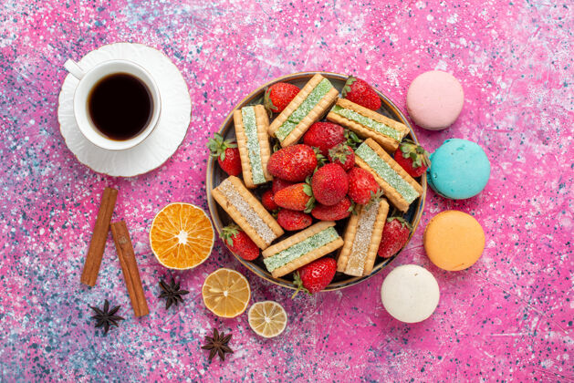 香料美味的华夫饼干顶视图 浅粉色表面有新鲜的红色草莓和麦卡龙食品水果新鲜