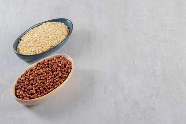 肾脏石桌上摆满了生豆子和长米饭的碗谷类豆类营养
