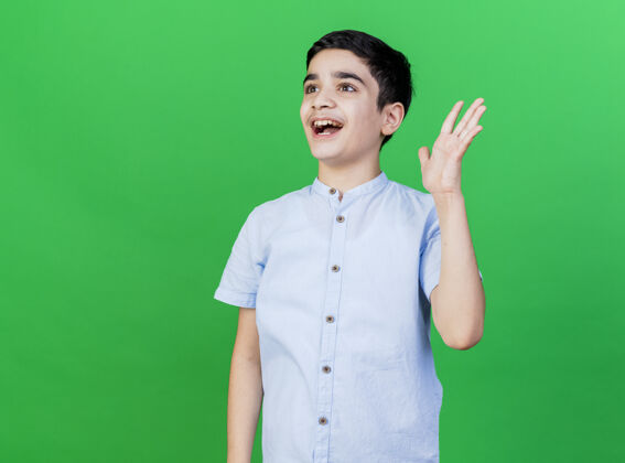 人一个年轻的男孩望着旁边的绿色墙壁 伸出一只空荡荡的手手衣服站