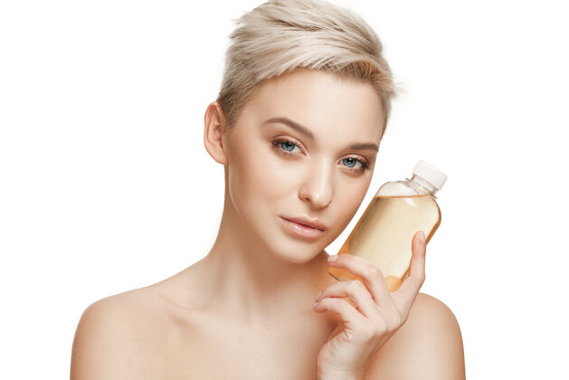 身体美丽的概念拥有完美皮肤的白种人美女拿着油瓶芳香美容爱