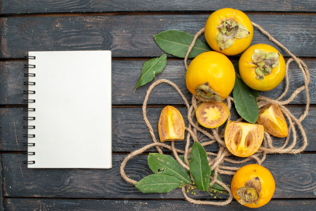 食品顶视图新鲜甜甜的柿子放在木质质朴的桌子上 水果醇香乡村绿色顶部