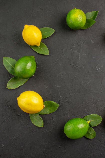 黄色顶视图新鲜的酸柠檬在深灰色的餐桌上柠檬柑橘类水果多汁水果食物