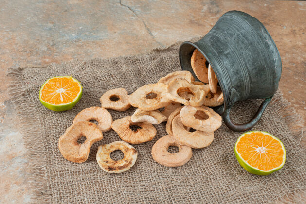 古董古老的茶壶装满了苹果干和半切的橘子好吃干的美味
