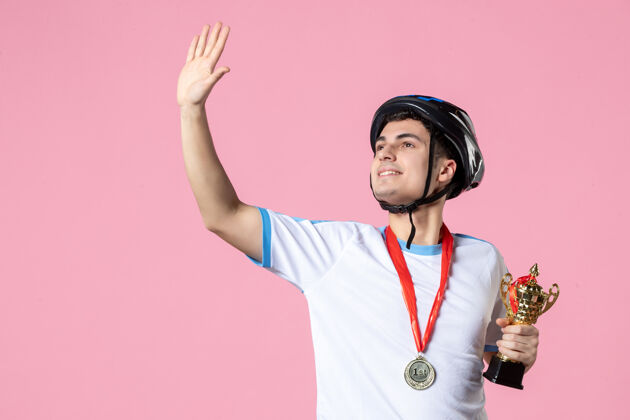 奖牌正面图挥舞着运动服的男运动员手持带头盔的金杯人粉红色水平