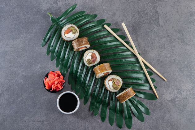 一餐美味的寿司卷配金枪鱼和绿叶腌姜美味切片卷