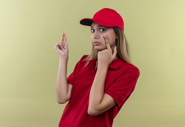 帽子悲伤的年轻送货女孩穿着红色制服 戴着绿色帽子手势悲伤制服