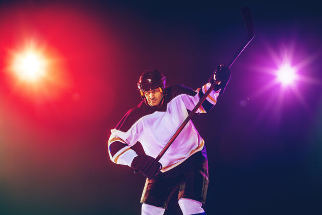 比赛冰球场上的棍子和深色霓虹灯墙的男性冰球运动员休息团队游戏