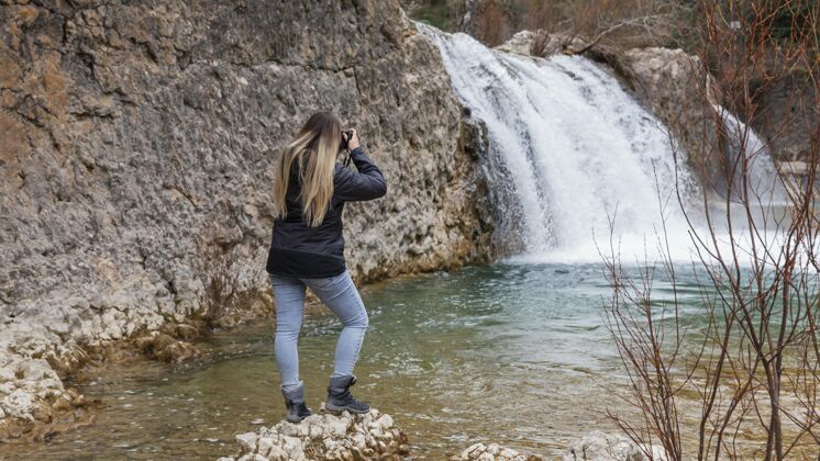 高山拍大自然照片的女人徒步旅行自然年轻人