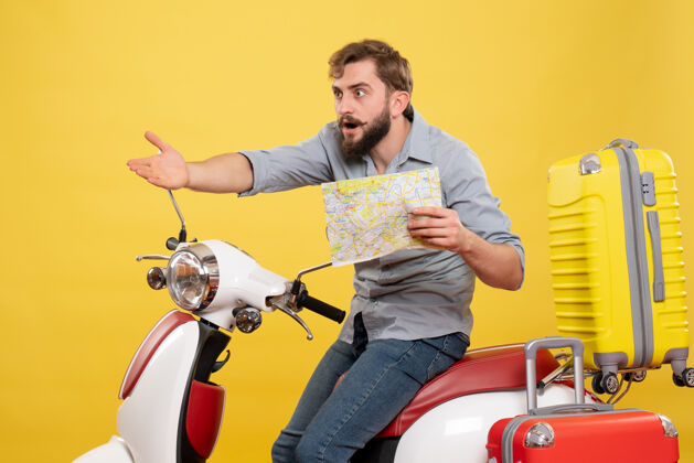 摩托车旅游概念与年轻好奇的胡须男子坐在摩托车和显示地图上的黄色表演微笑地图